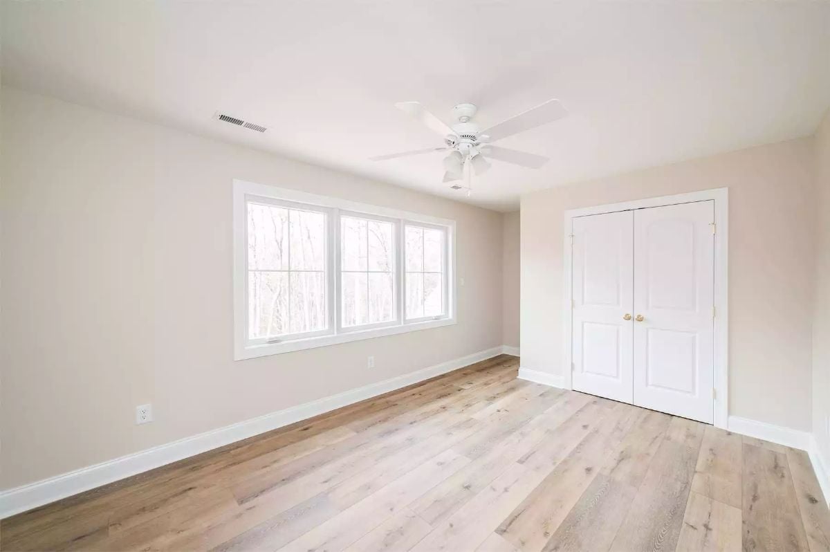 Double Closet Doors and Natural Light Define This Bedroom's Simple Appeal