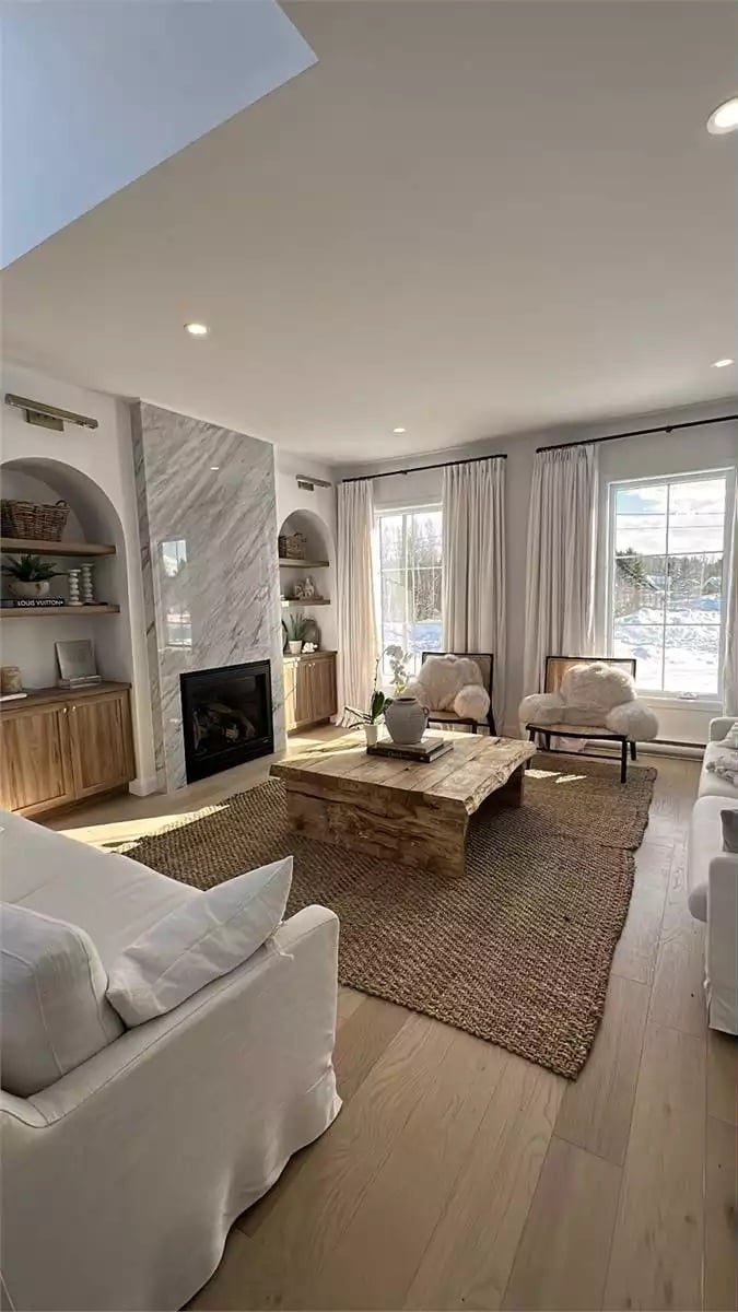 Marble Fireplace Wall Anchors a Living Room Built Around Natural Materials