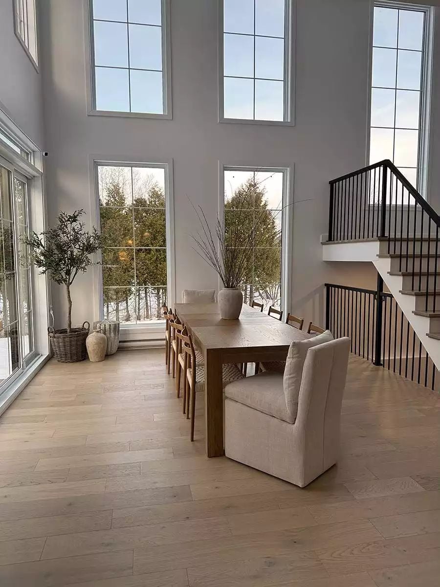 Double-Height Windows Flood a Dining Room with Winter Light