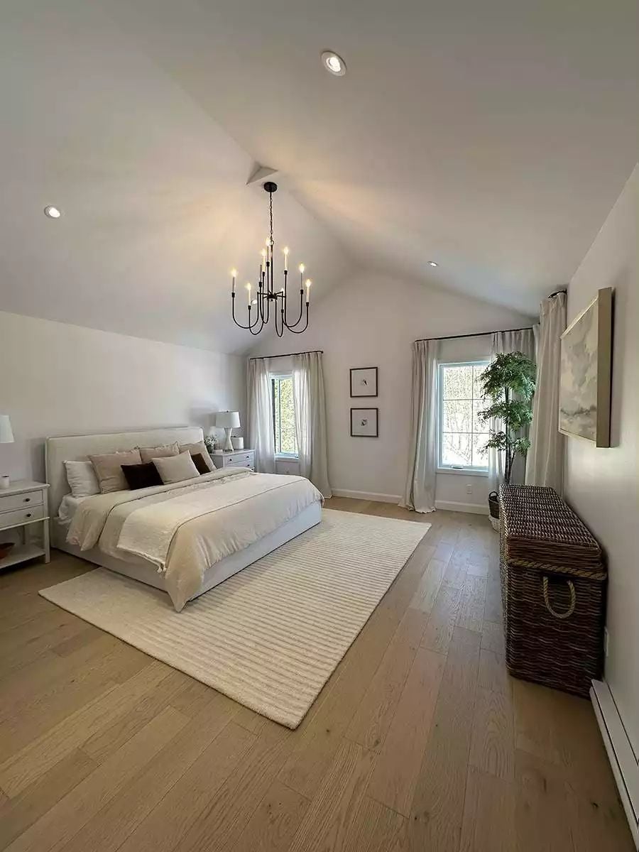 Vaulted Ceiling and Chandelier Give a Primary Bedroom Room to Breathe