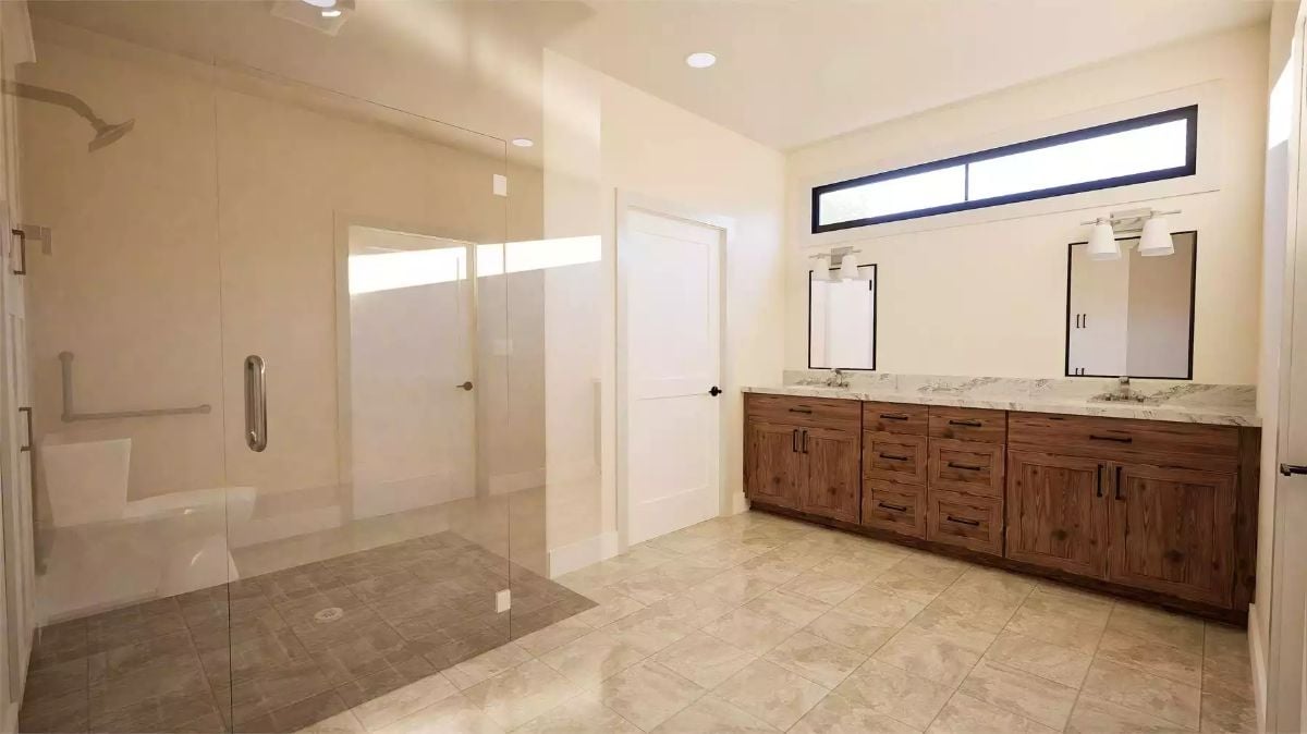 Warm Wood Cabinetry and Marble Counters Anchor a Spacious Double-Vanity Bath