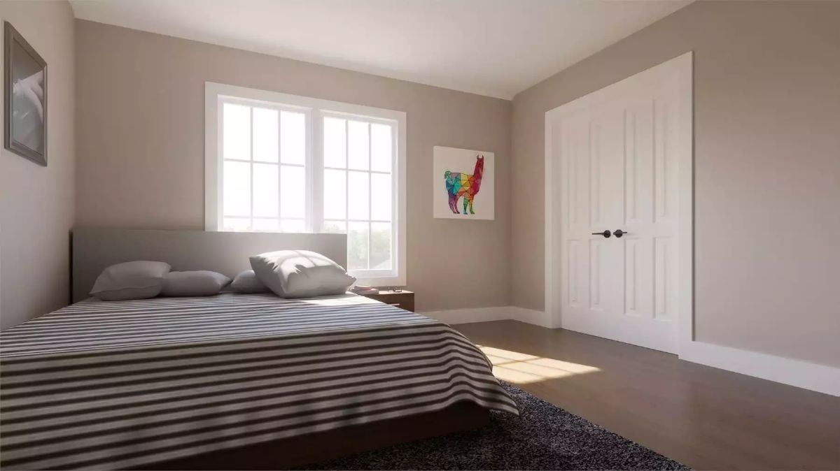 Striped Bedding and Warm Wood Floors Anchor a Sun-Washed Country Bedroom