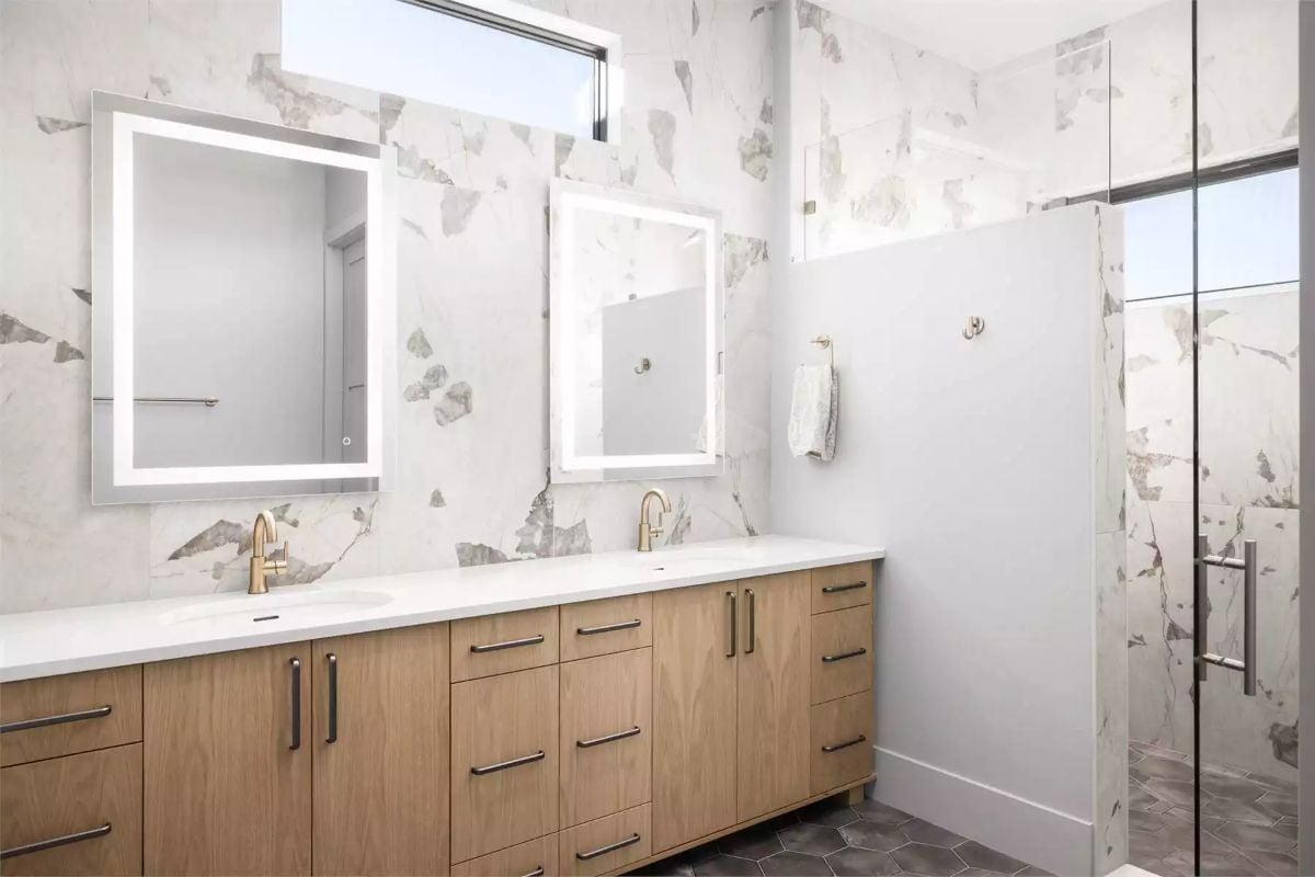 Warm Oak Vanity, Brass Fixtures, and Marble That Covers Every Wall