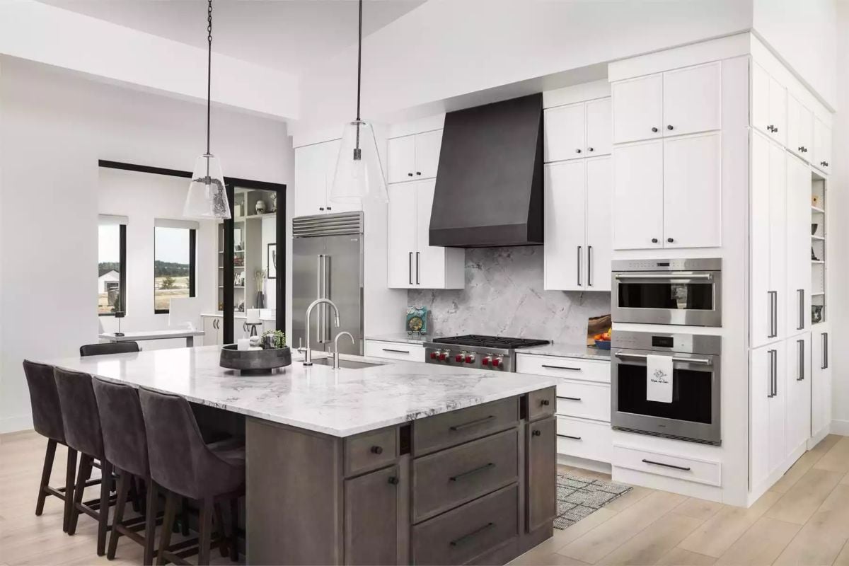 Marble Backsplash and Black Range Hood Define a Kitchen Built to Work Hard