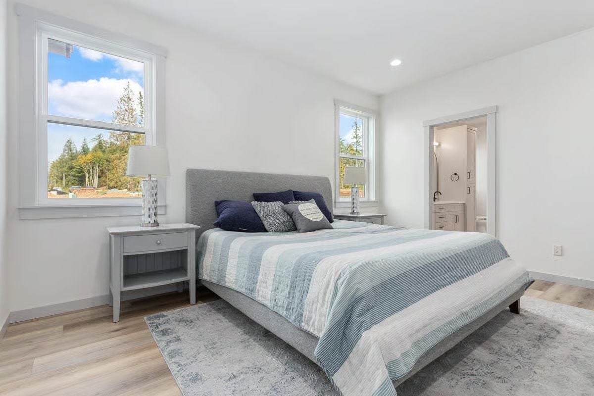 Gray Upholstered Bed and Blue Stripe Bedding in a Bright Primary Suite