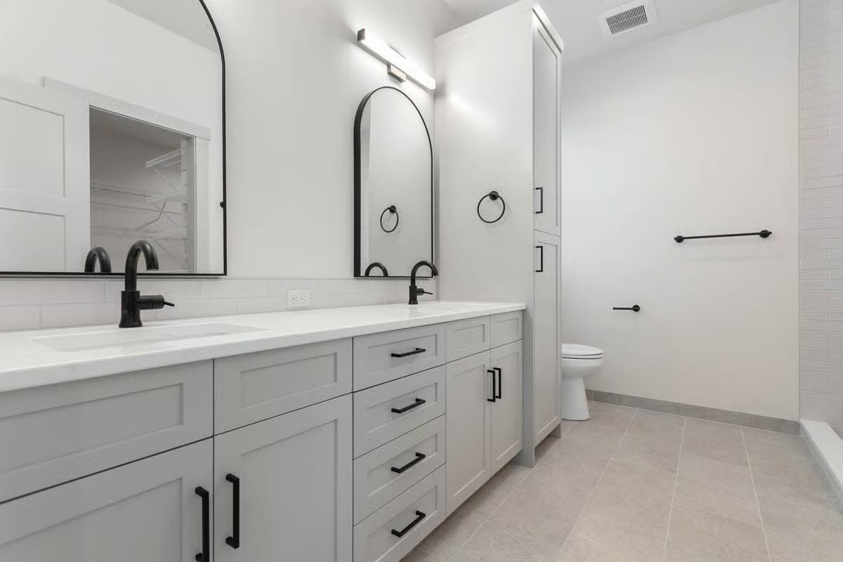 Arched Black Mirrors and Matte Fixtures in a Double-Vanity Primary Bath