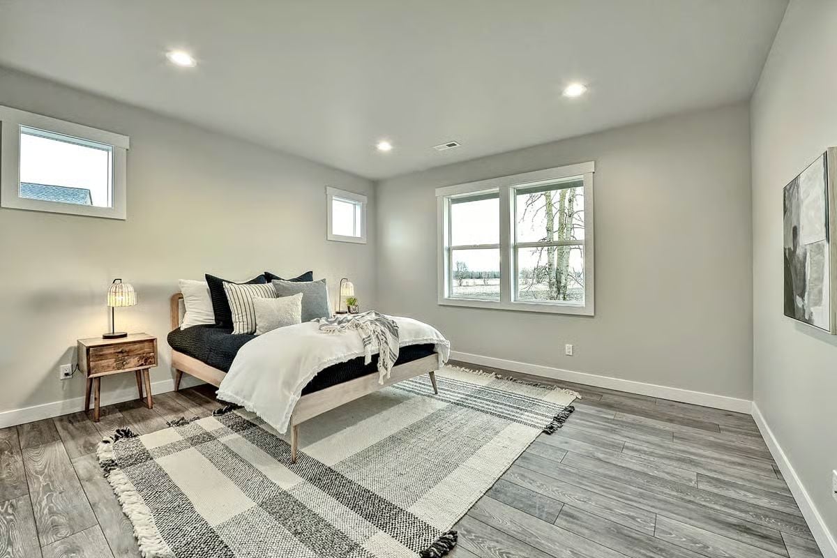 Layered Bedding and a Plaid Rug Ground This Neutral Bedroom Without Overstyling It
