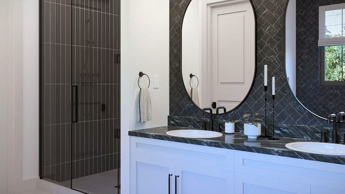 Oval Mirrors and Marble Countertops in a Bathroom Built Around Contrast
