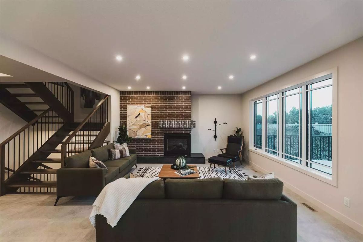 Dark Sofas, Brick Fireplace, and a Staircase That Earns Its Keep
