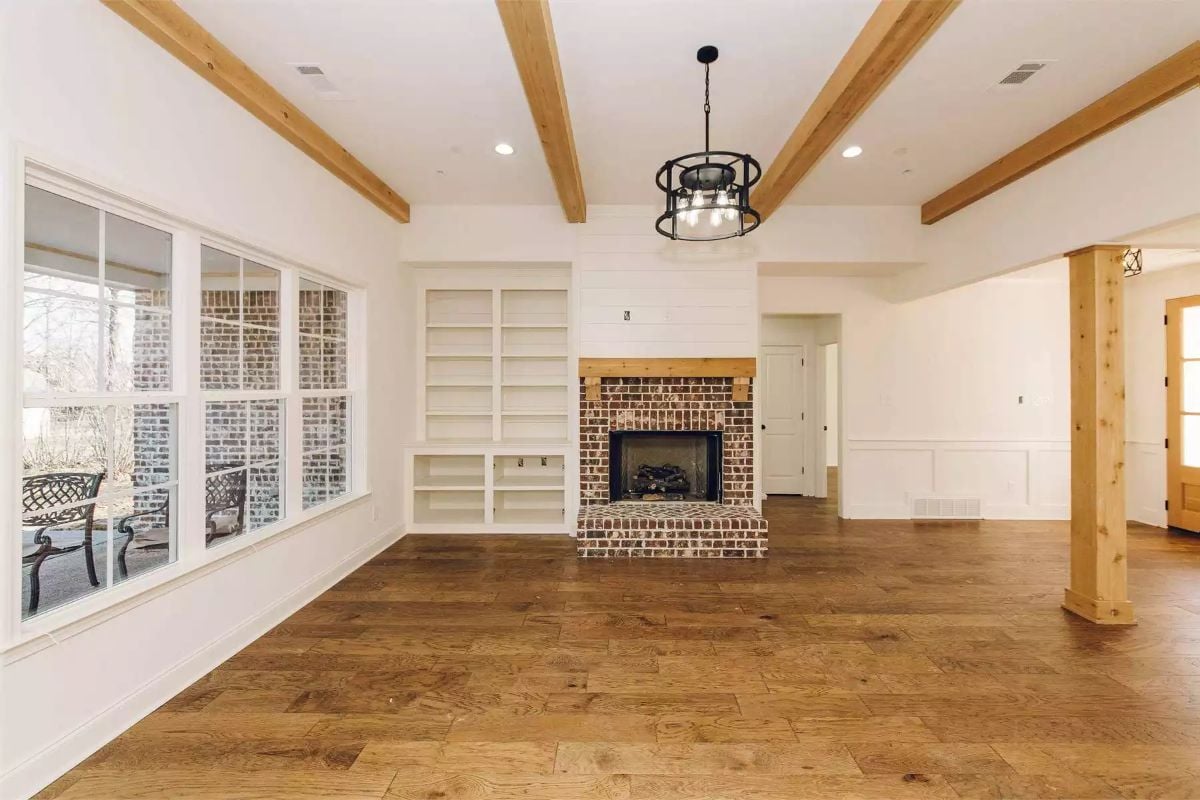 Exposed Beam Ceiling and Brick Fireplace Anchor the Open Living Room