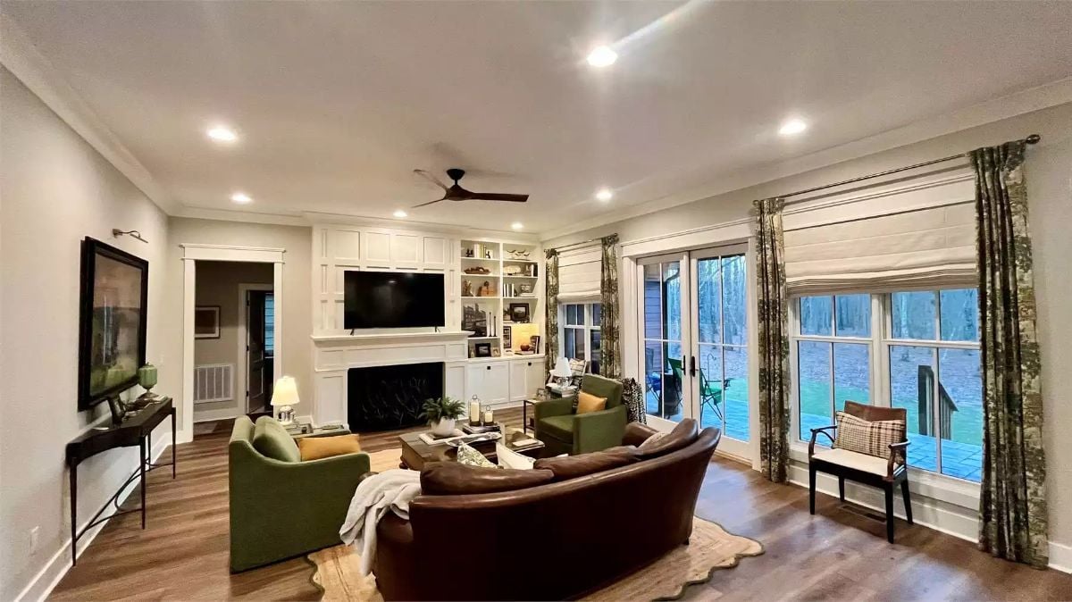Curved Leather Sofa Pulls the Eye Toward a Built-In Fireplace Wall