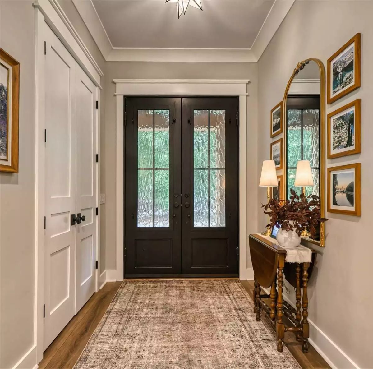 Black French Doors Anchor a Foyer Built Around Warm Antique Gold