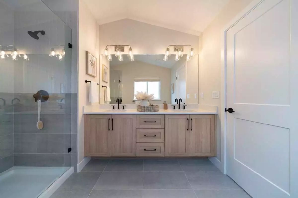 Floating Vanity and Black Hardware Keep This Primary Bath Grounded