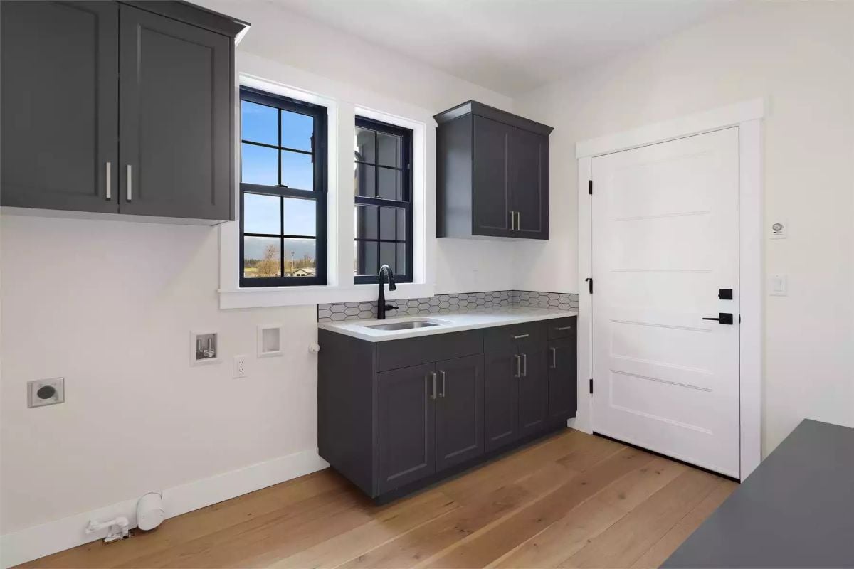 Matte Black Fixtures and Gray Shaker Cabinets Set the Tone in the Laundry Room