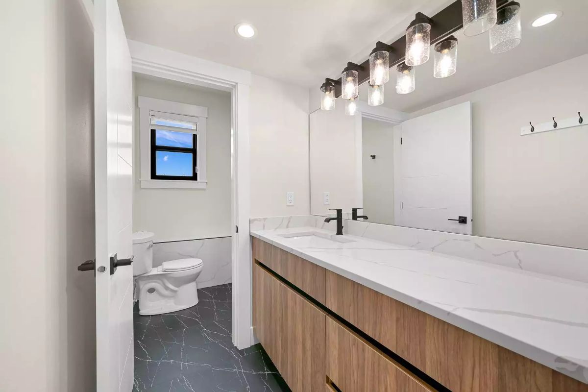 Floating Wood Vanity With Marble Countertop and a Separate Toilet Room