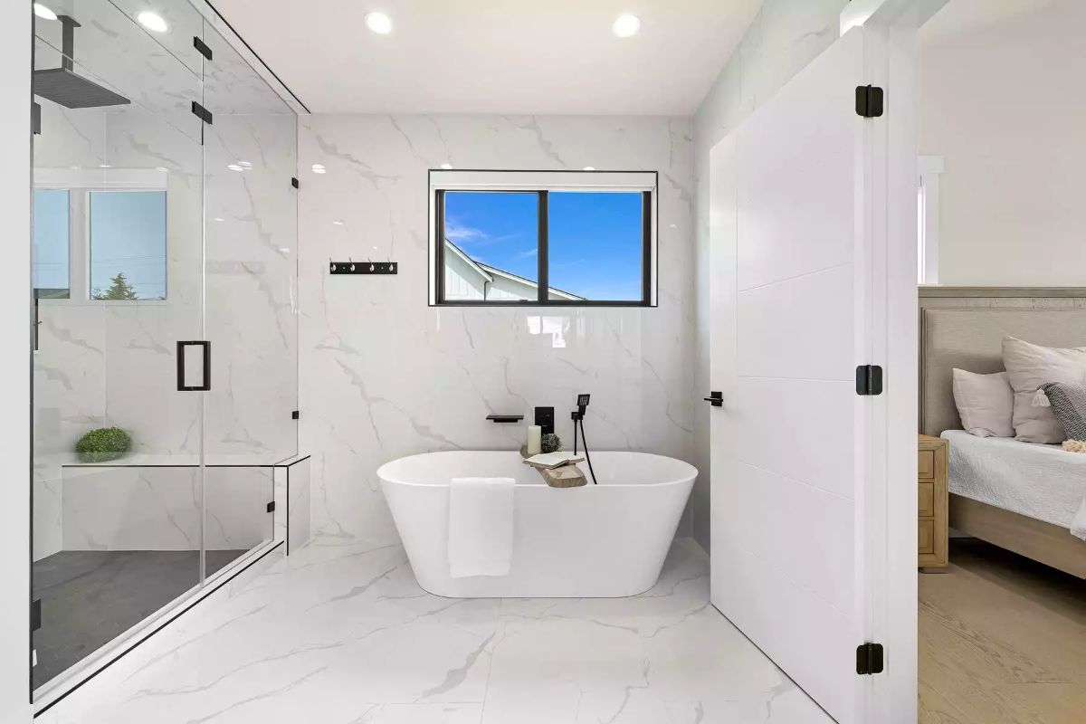 Freestanding Soaking Tub Centered Against Full-Slab Marble Walls