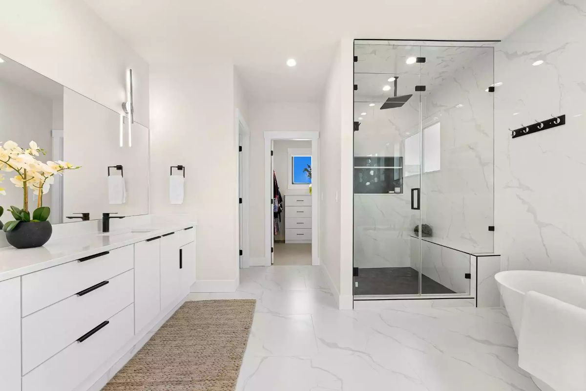 Marble Shower Enclosure With a Rain Head and a Bench Built Into the Wall