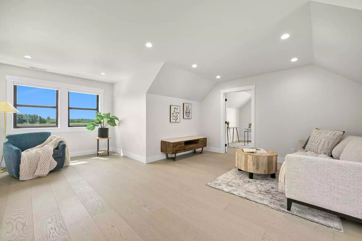 Vaulted Bonus Room With Hardwood Floors and a View of Open Fields