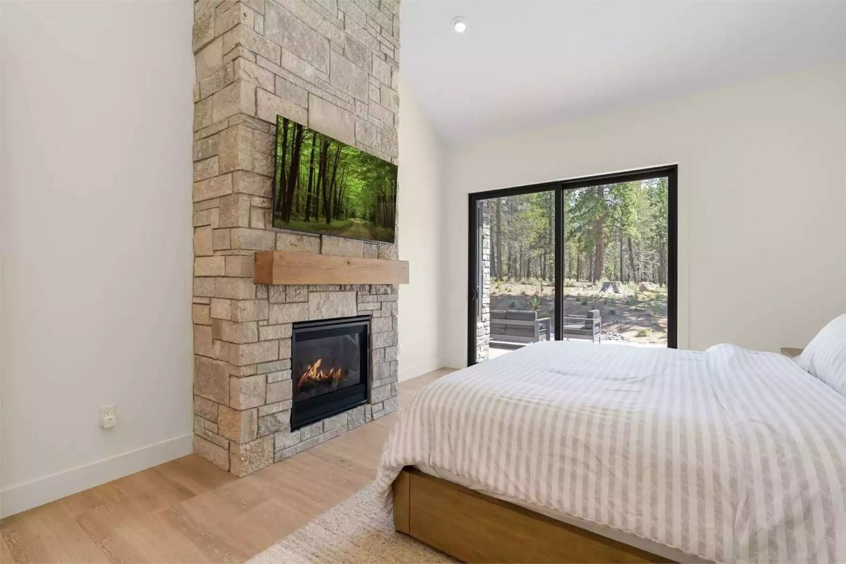 Stone Tower, Wood Mantel, and Sliding Glass That Frames the Forest