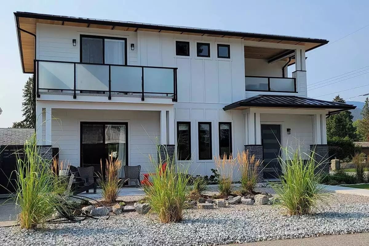 Board-and-Batten White, Black Railing, and a Gravel Yard That Skips the Lawn Entirely