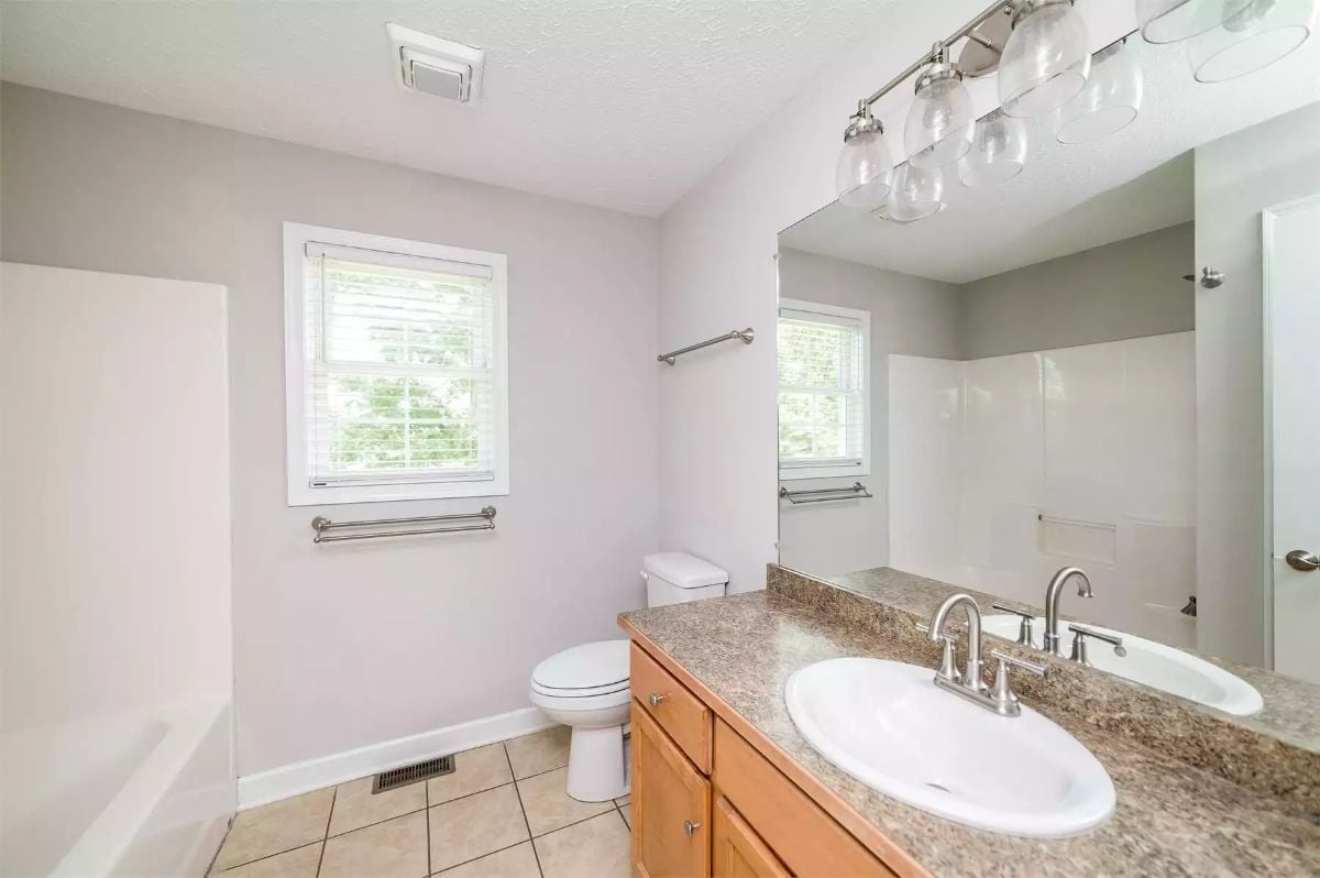 Granite Counters, Globe Sconces, and a Double-Sink Vanity That Earns Its Footprint