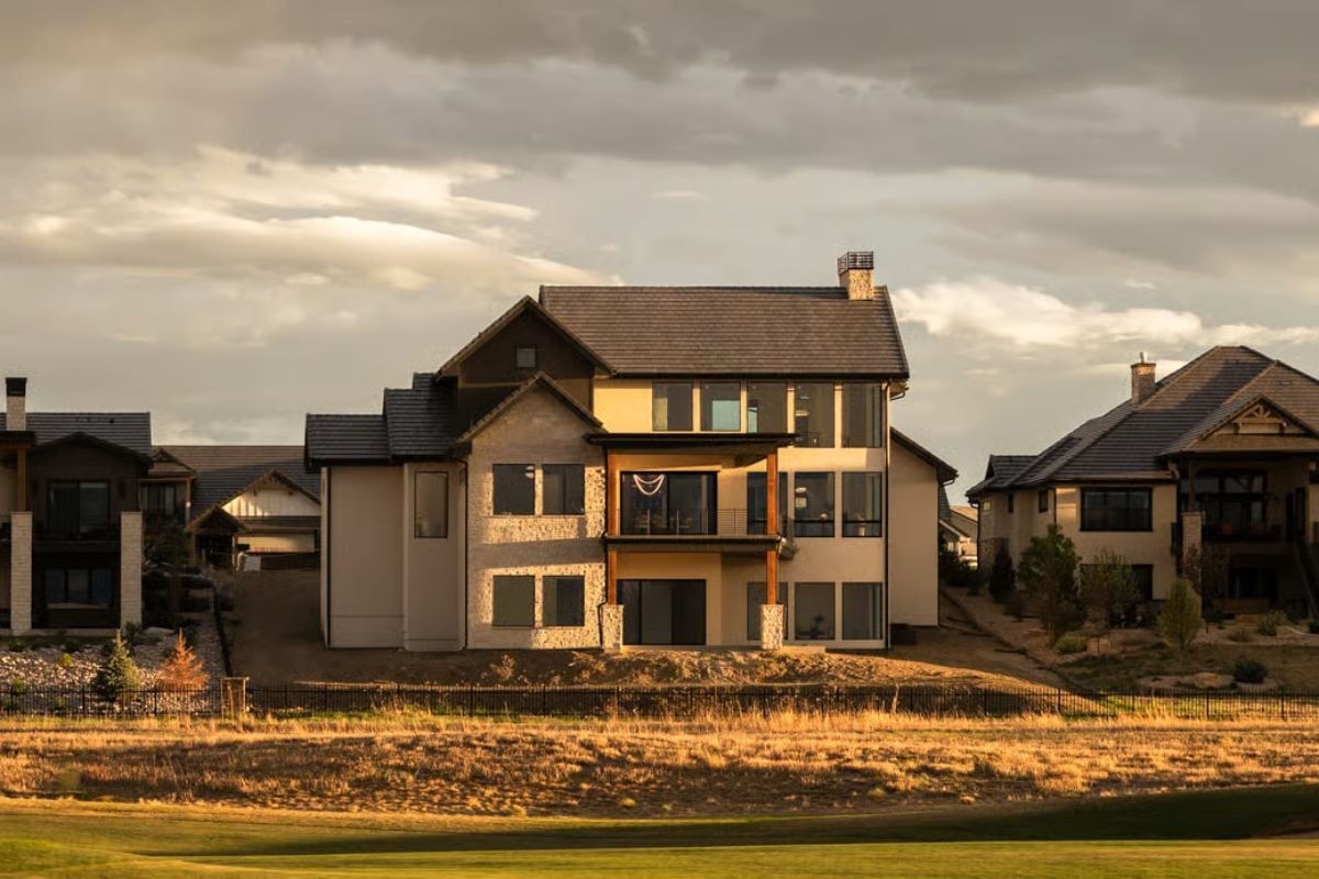 Warm Light Catches Stone Columns and Stacked Glass on the Back Elevation