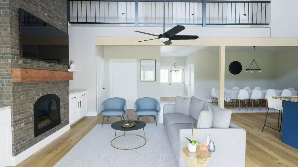 Brick Fireplace Wall, Loft Railings, and Two Blue Chairs That Anchor the Room