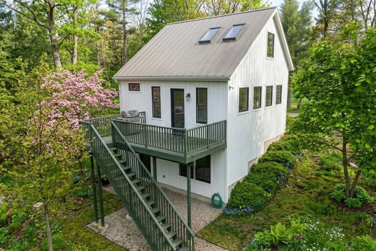 Green-Painted Deck Stairs and a Blooming Magnolia Make the Exterior Feel Like a Retreat