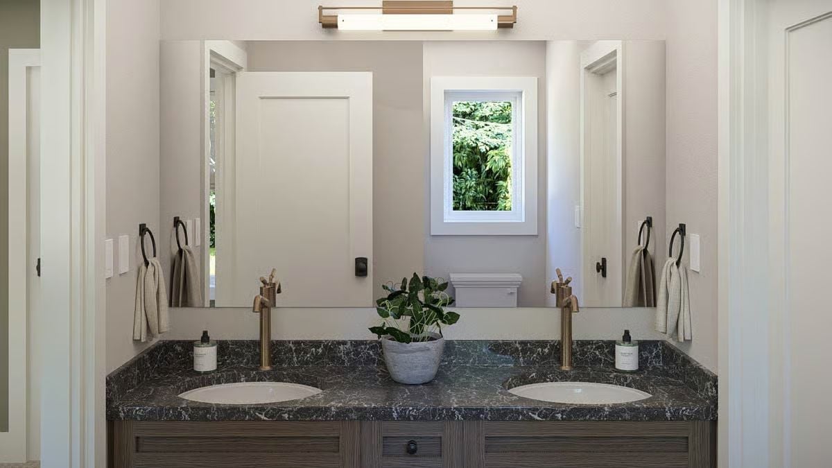Dark Marble, Brass Faucets, and a Potted Plant That Pulls It Together