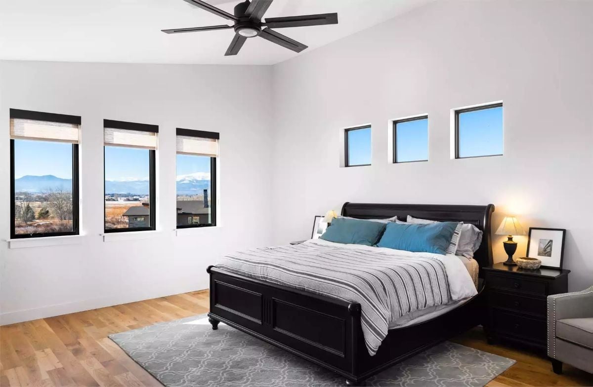 Black Sleigh Bed, Teal Pillows, and Mountain Views Through Six Windows