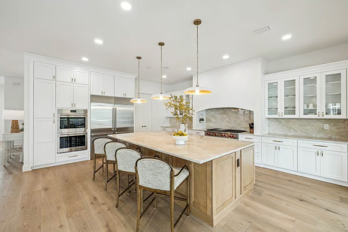 Gold-Toned Pendants and a Natural Wood Island Anchor This Kitchen Without Competing