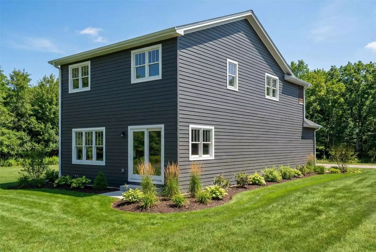 Dark Slate Siding That Earns Its Place Against a Green Backdrop