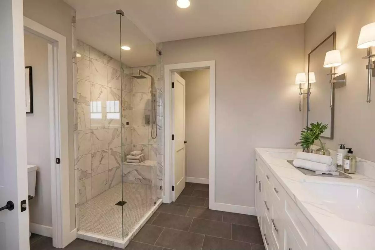 Marble Tile Inside a Glass Shower Enclosure Does the Heavy Lifting Here