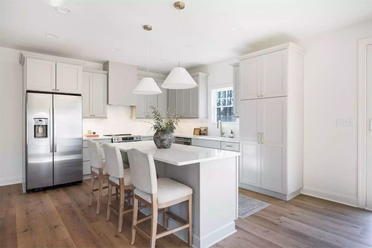 Warm Wood Floors Keep This White Kitchen from Feeling Cold