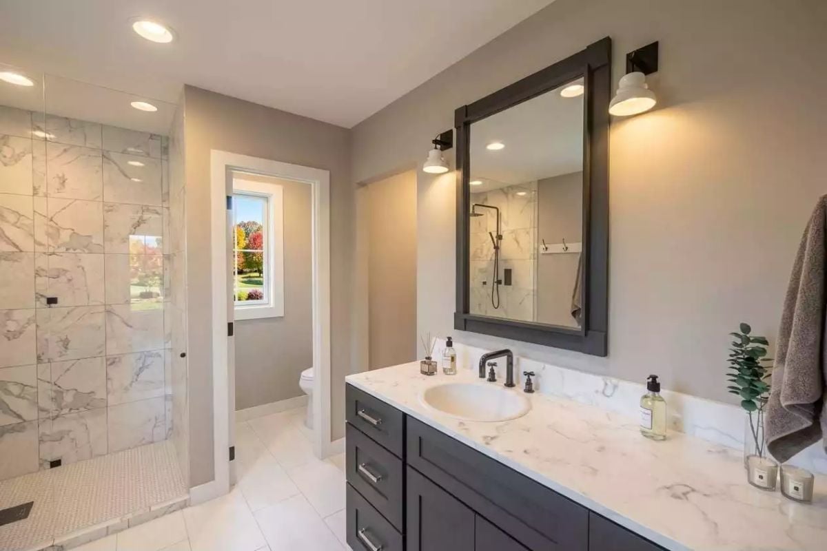 Marble Tile Shower Wall and Dark Vanity Cabinet Pulling the Room in Two Different Directions