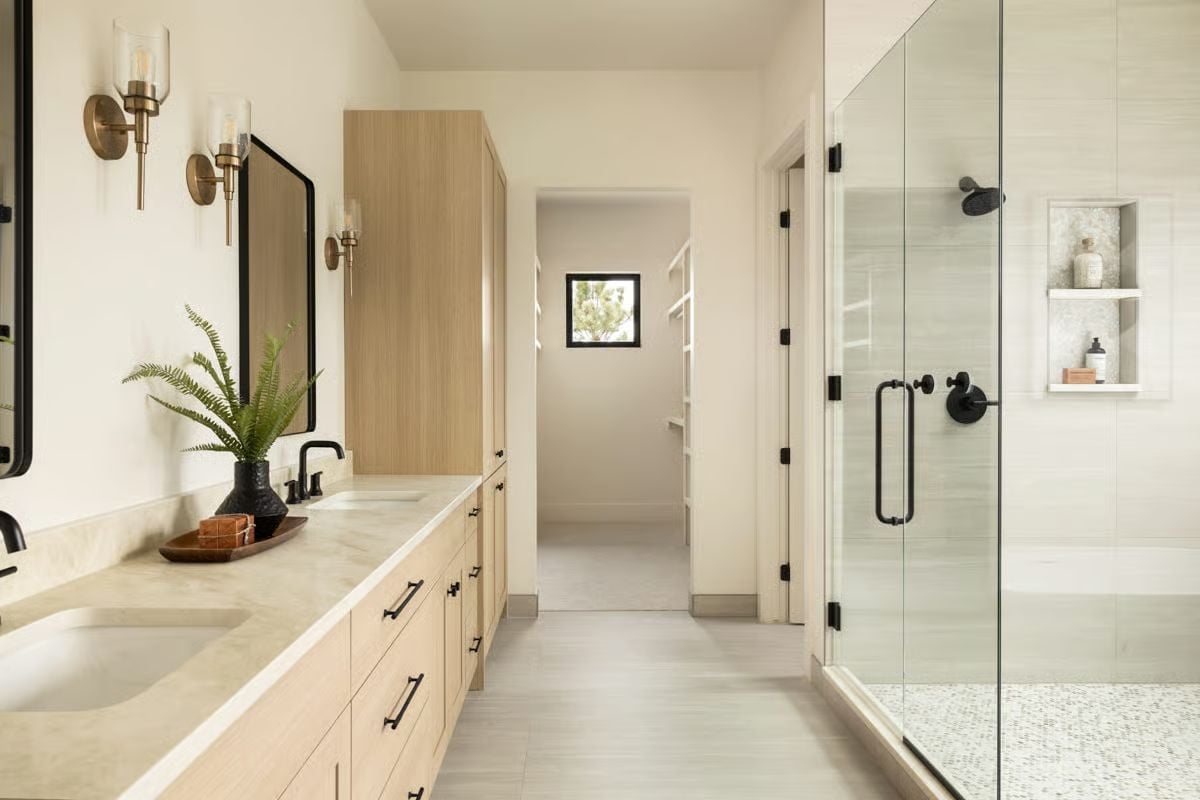 Warm Stone Counters and Matte Black Hardware Ground This Primary Bath