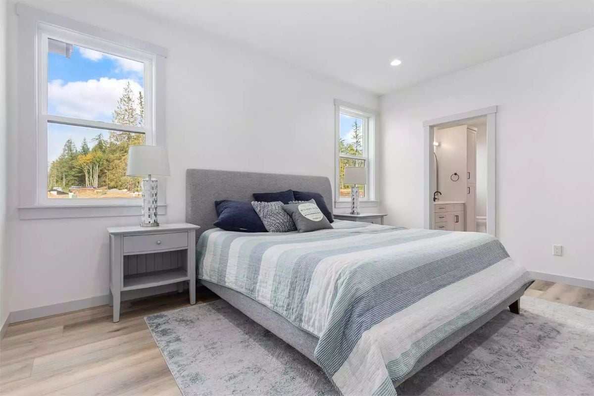 Upholstered Headboard and Striped Bedding Keep This Primary Suite Calm