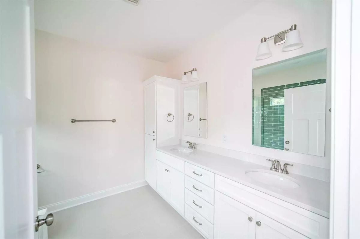 Double Sinks, a Tower Cabinet, and Green Subway Tile Stealing Focus from the Back
