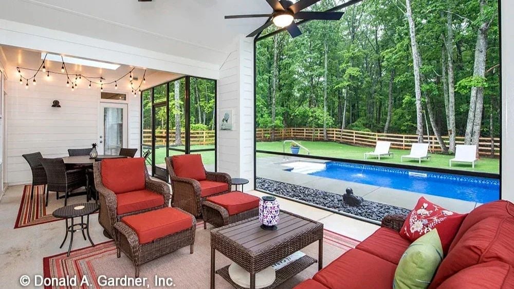 Wicker Seating and Red Cushions Frame a Covered Porch Built for Poolside Lounging