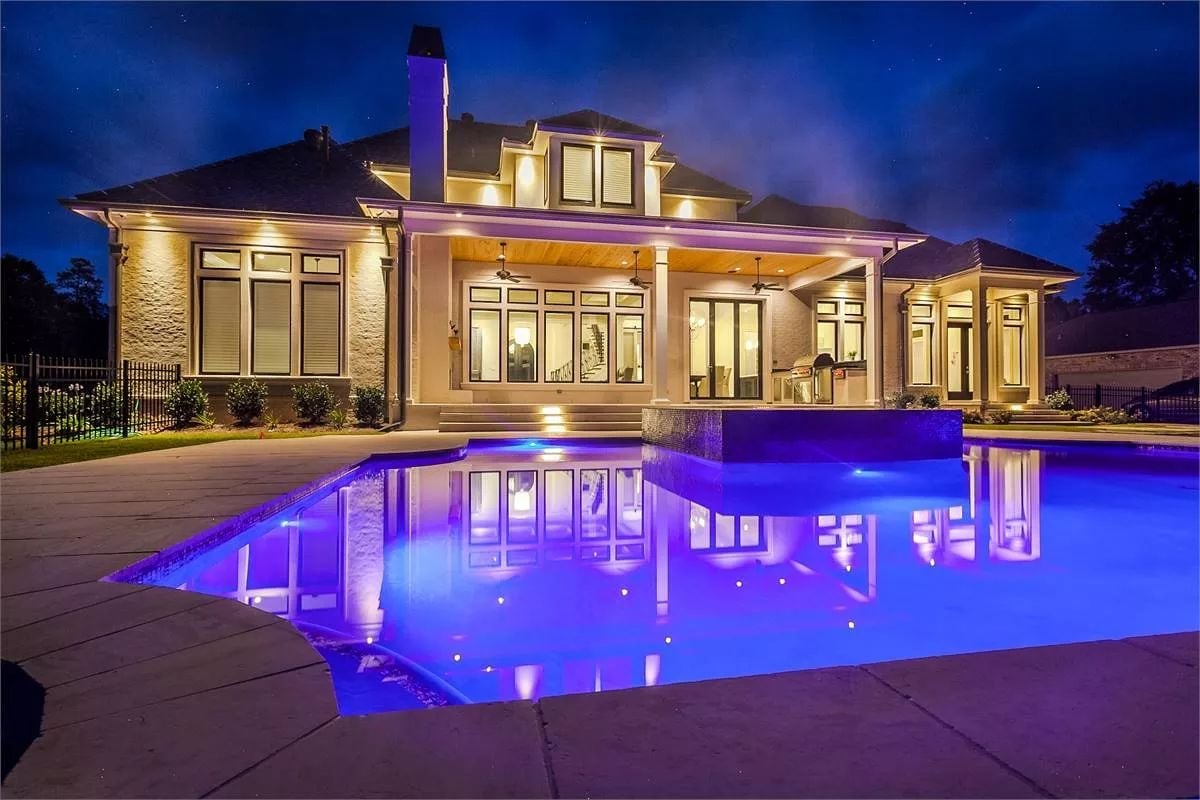 Purple-Lit Pool Reflects the Whole Back Elevation After Dark
