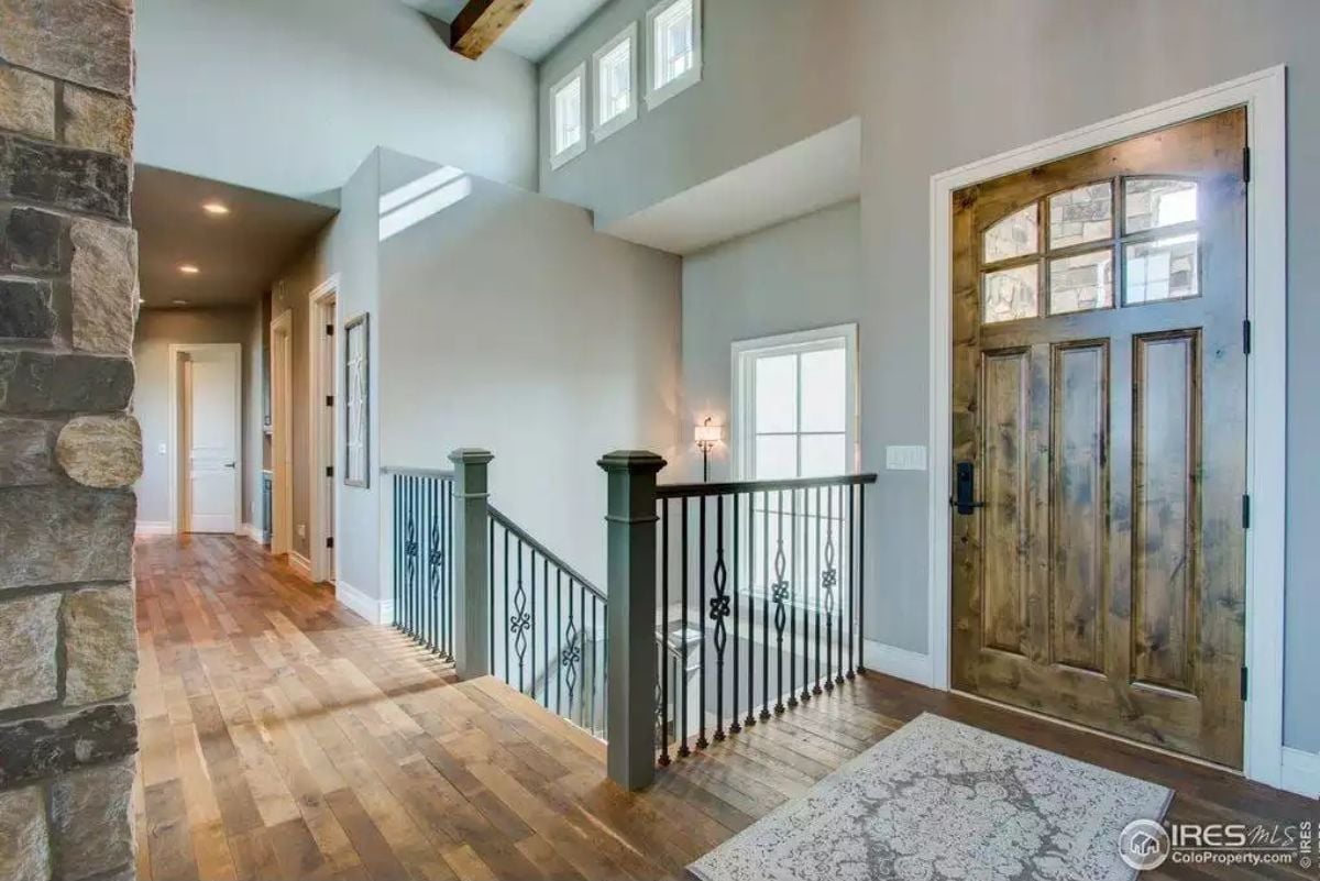 Iron Balusters, a Knotty Wood Door, and Clerestory Windows That Pull Their Weight