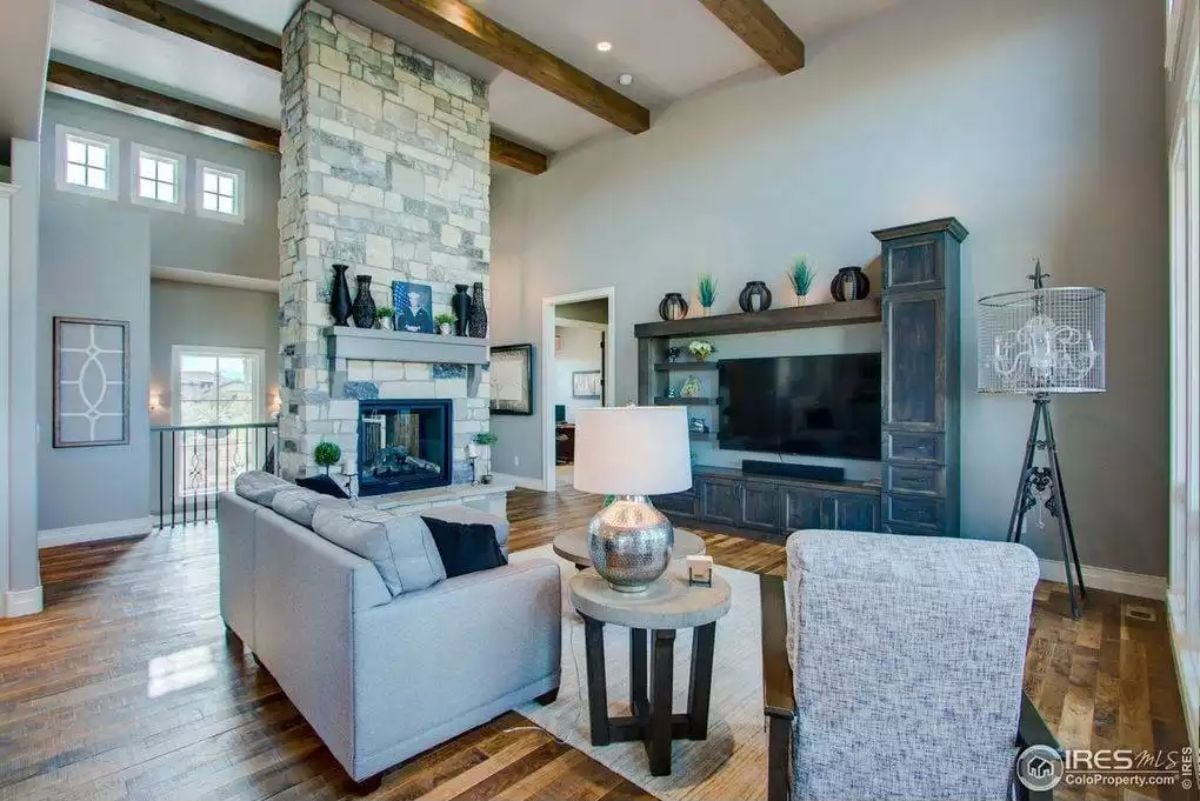 Stone Fireplace Tower, Exposed Beams, and a TV Wall That Actually Keeps Up
