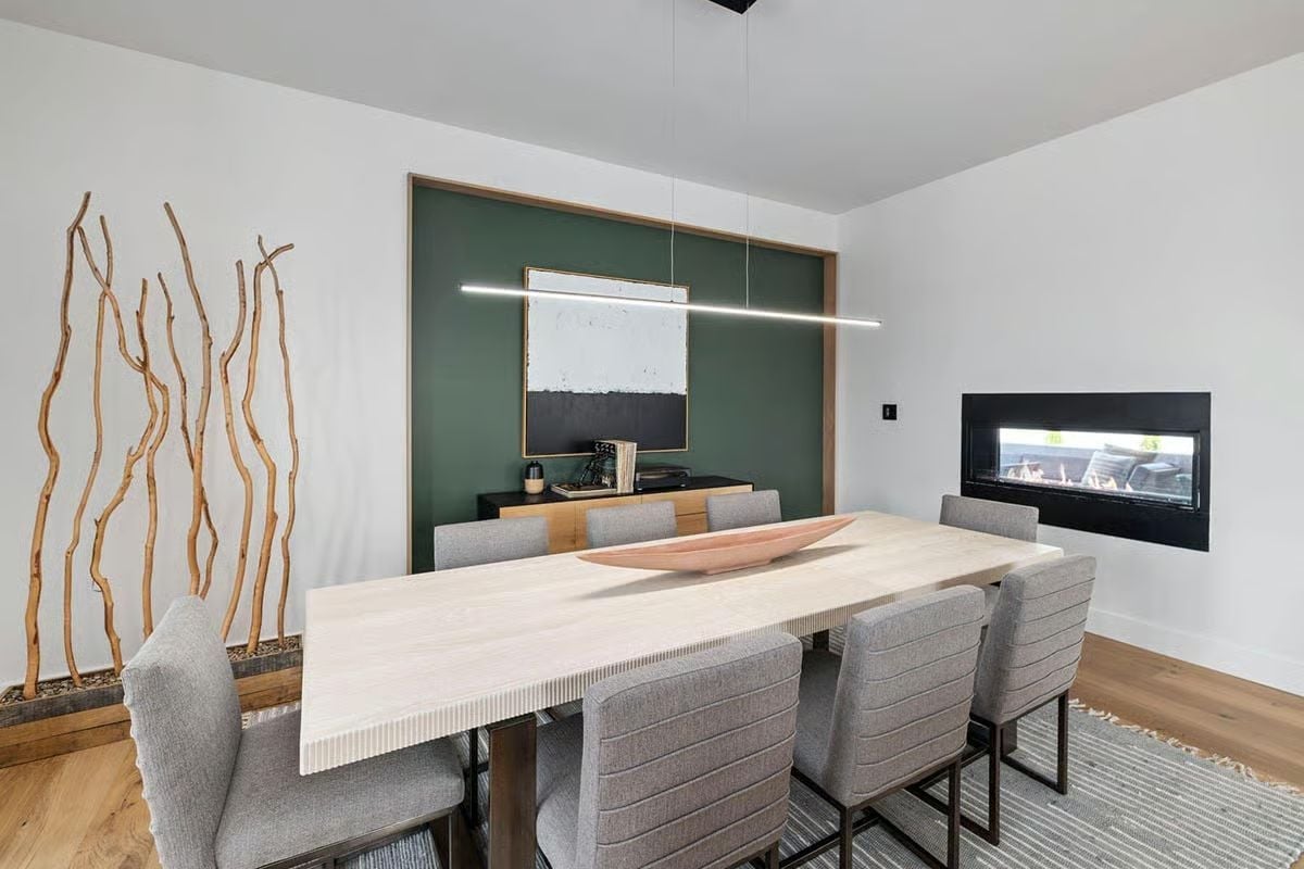 Green Accent Wall, Bare Branches, and a Fireplace That Has No Business Being That Sleek