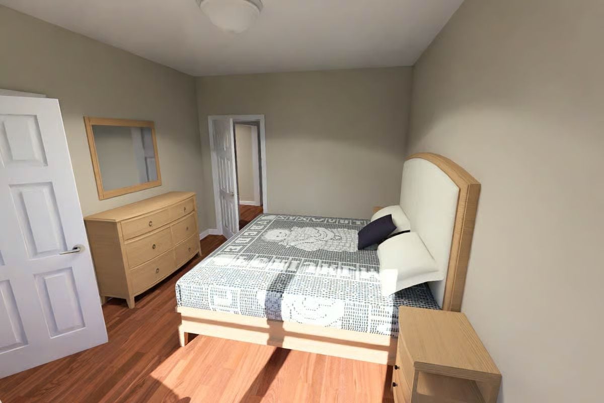 Oak Furniture and a Patterned Coverlet Keep This Bedroom from Feeling Too Serious