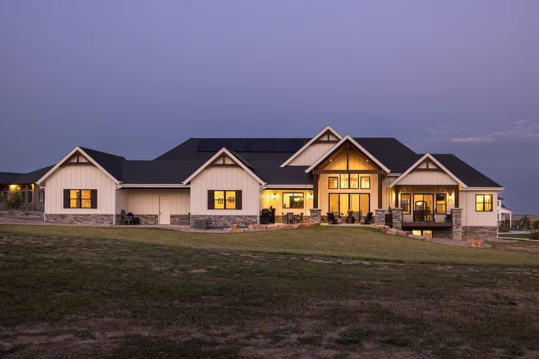 Solar Panels, Stone Base, and Warm Light at Dusk Make This Farmhouse Earn Its Keep
