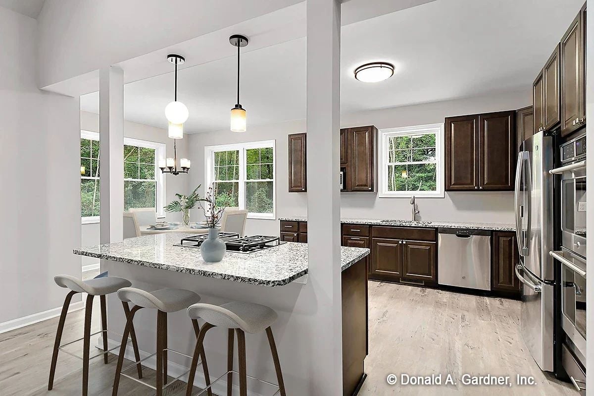 Granite Peninsula, Gas Cooktop, and Barstools That Invite You to Stay