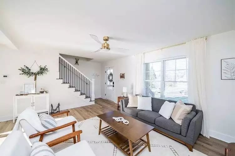 Brass Ceiling Fan, Gray Sofa, and a Staircase That Actually Earns Its Place