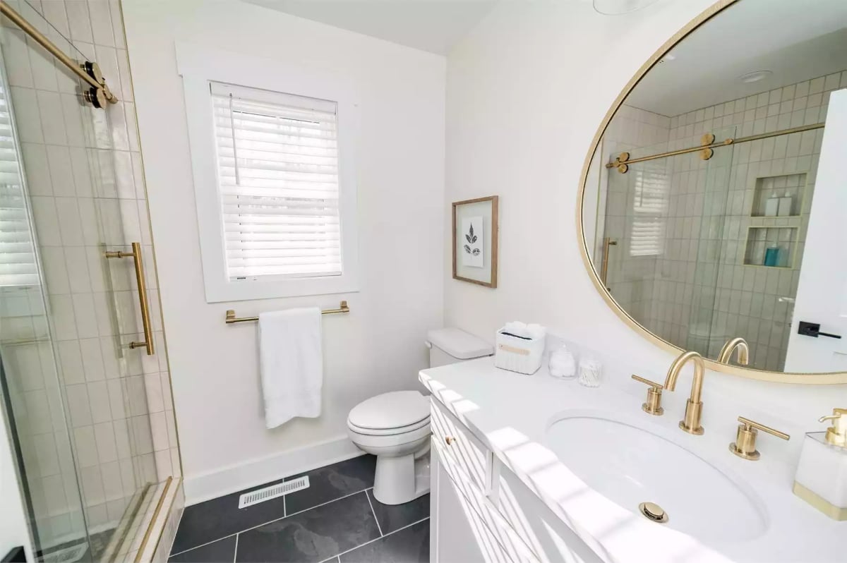 Gold Fixtures, White Vanity, and a Round Mirror That Actually Fits the Wall