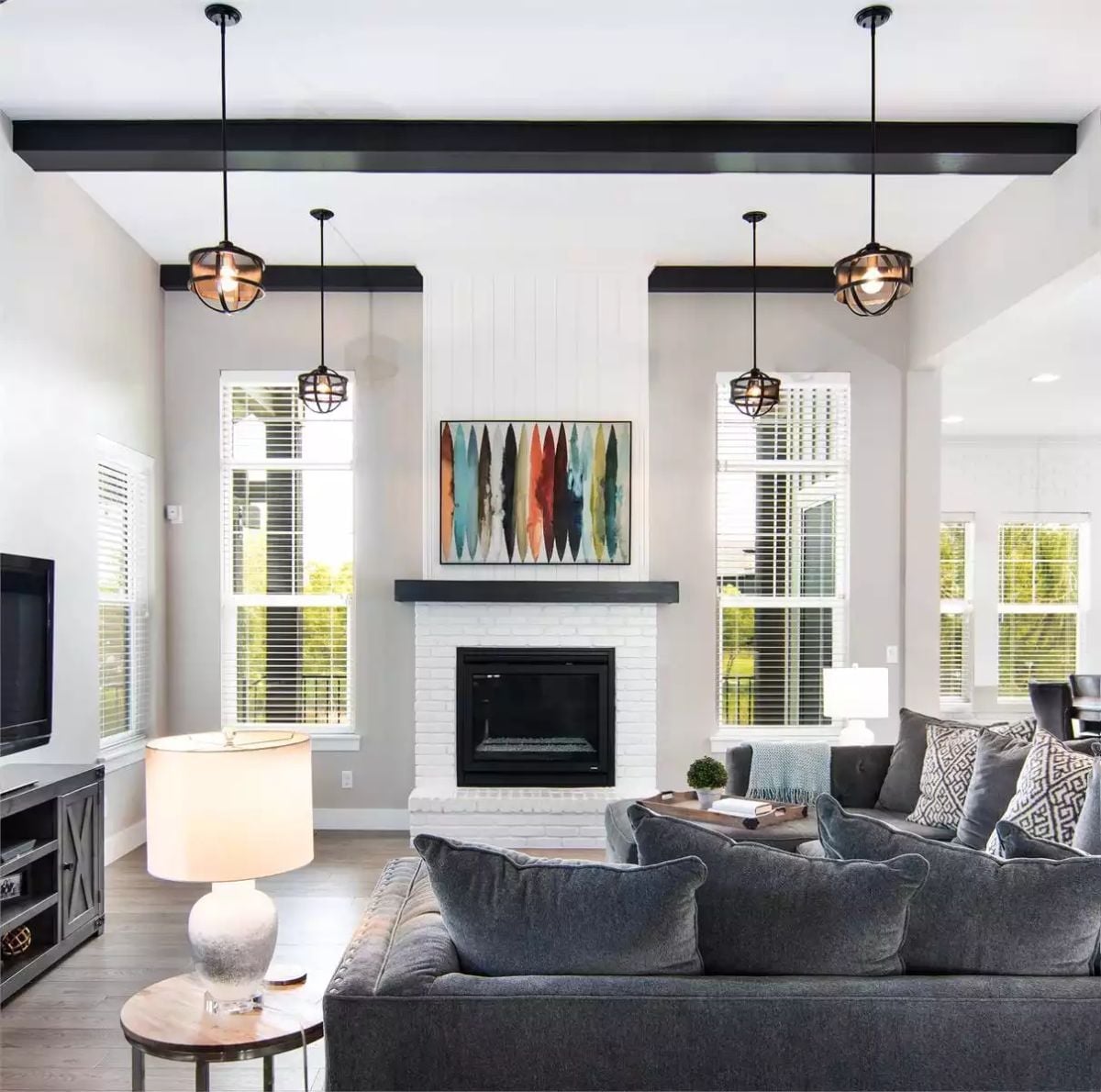 Cage Pendants, Black Beams, and a Fireplace Wall That Earns Its Square Footage