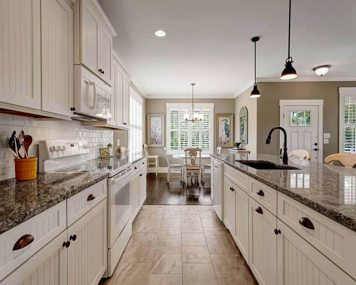 Pendant Lights and Dark Hardware Do the Heavy Lifting in This Galley Kitchen